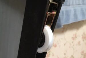 A white tape dispenser on the side of a black cabinet.