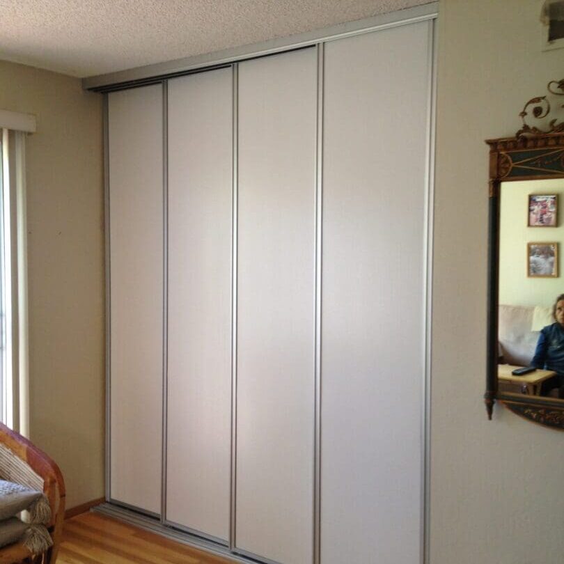 A room with a mirror and some sliding doors