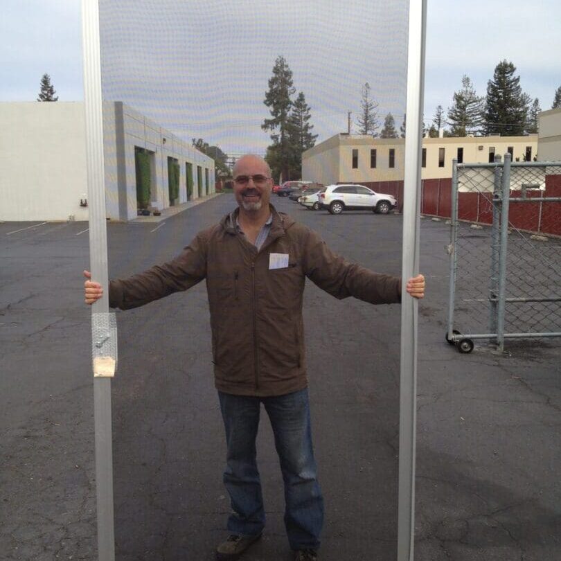 A man standing in front of a large window.